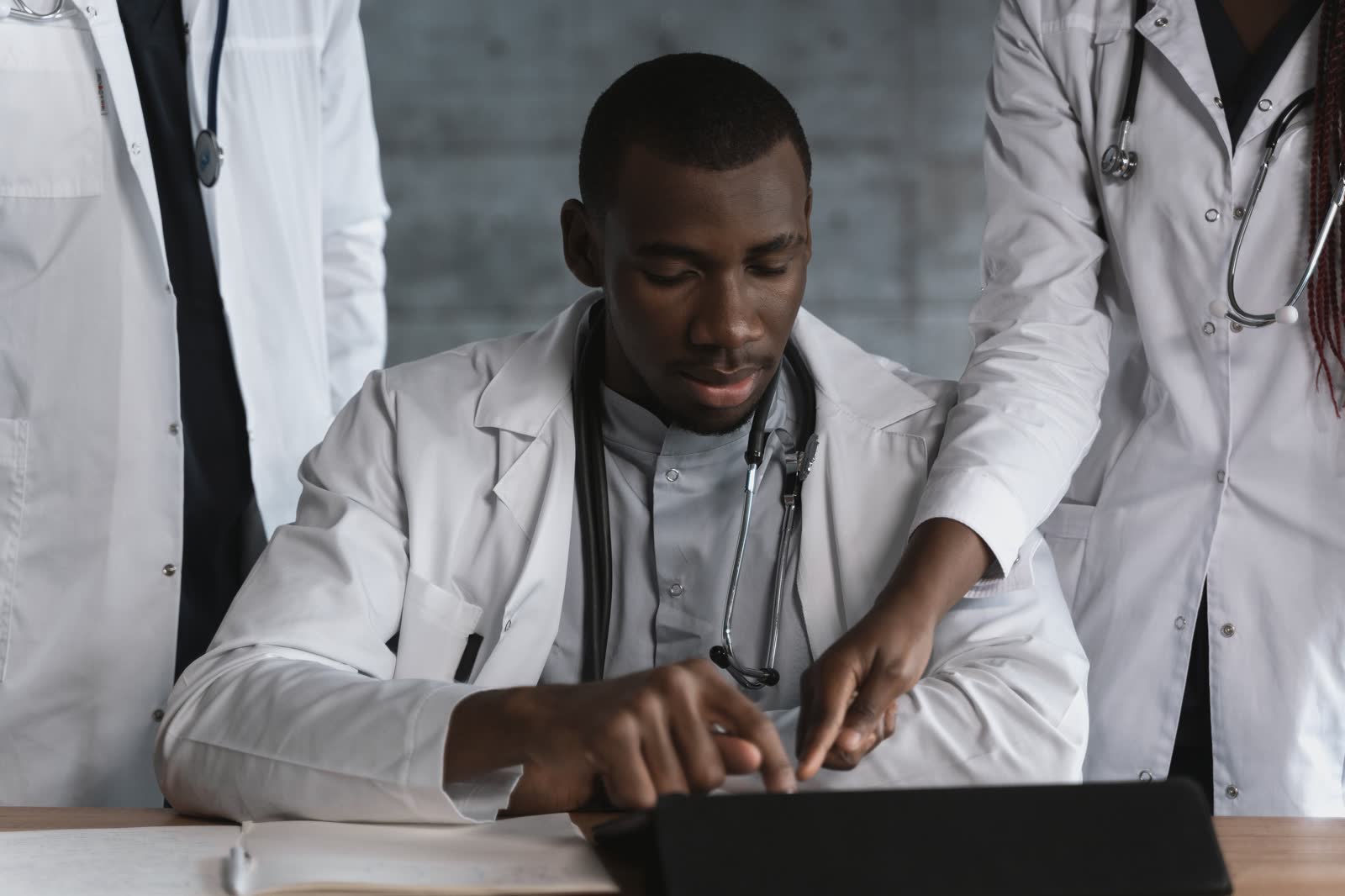 A medical professional reviewing documents on a tablet